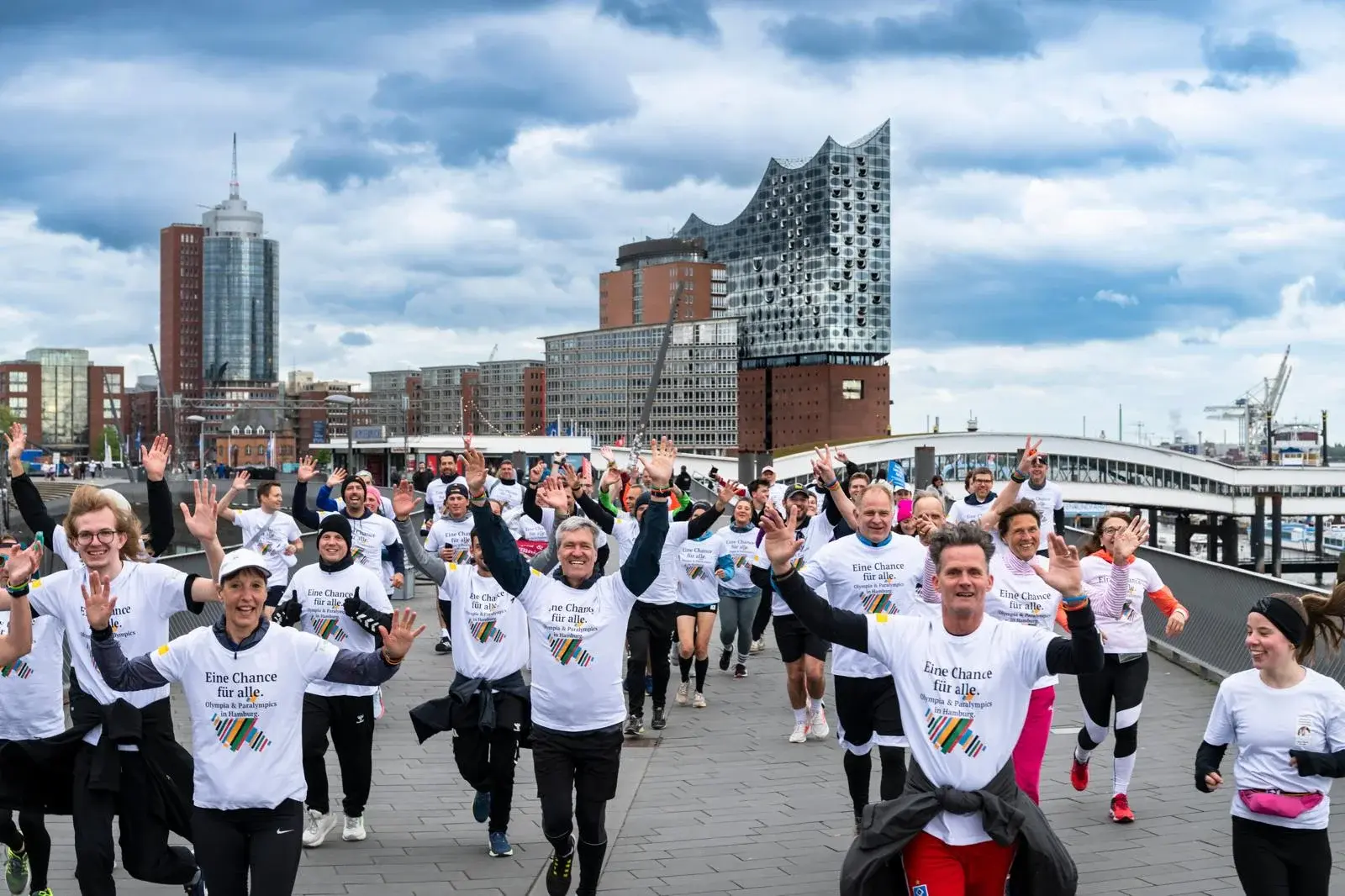 Run-for-Olympia-Gruppe in Bewegung vor der Hamburger Hafenkulisse